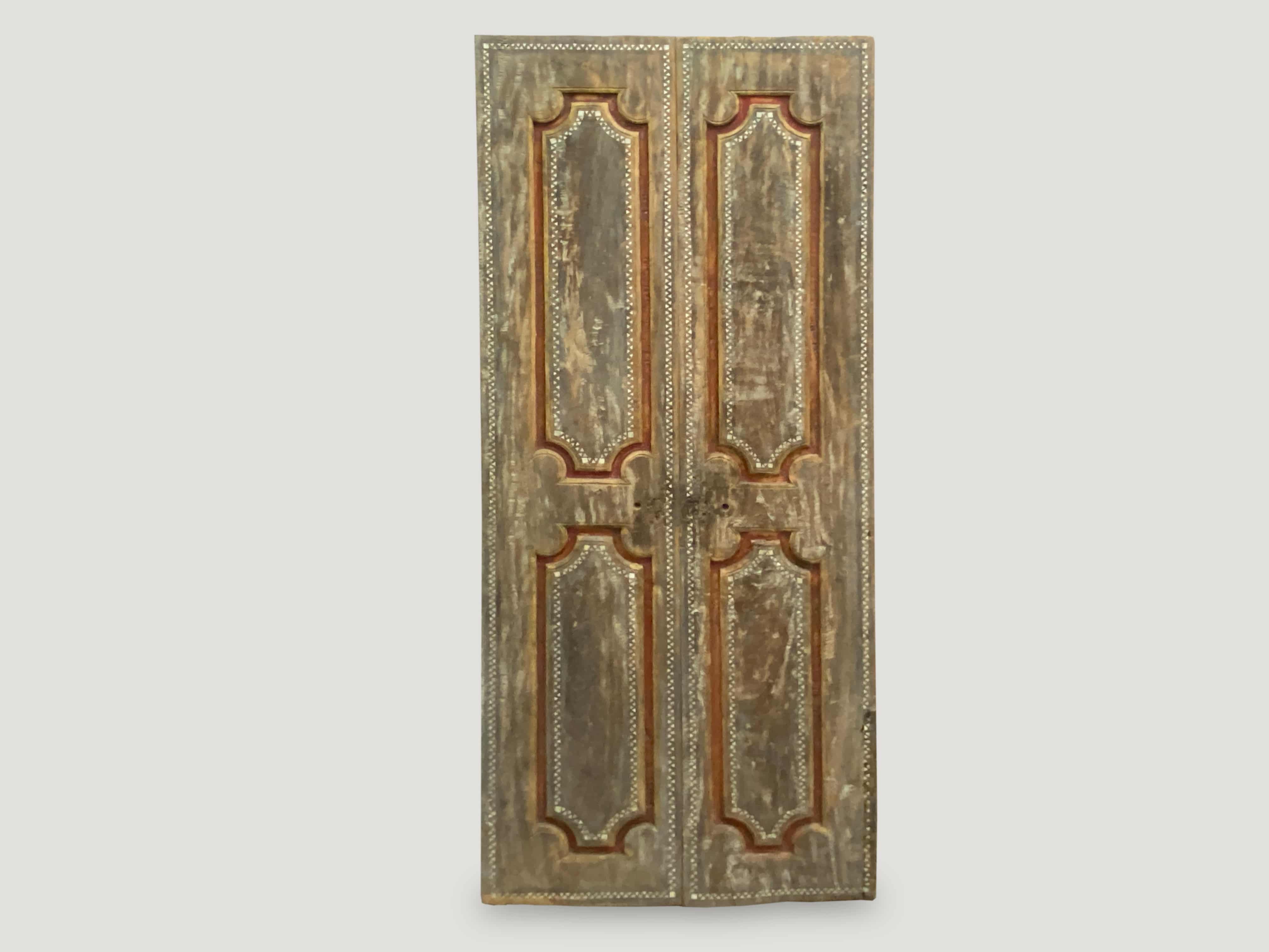 Antique temple door in teak wood with remnants of the original color.